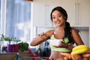 Woman eating a bowl of fruit – Defence Supplements Collection